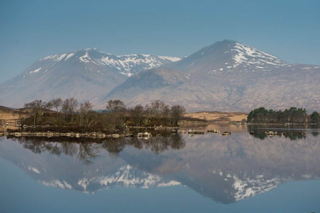 snow capped mountains reflected in scottish loch